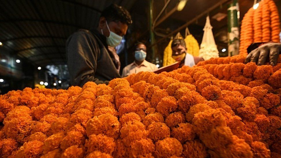 Цветочные гирлянды выставлены в магазине на цветочном рынке перед Дивали, индуистским фестивалем огней, в Нью-Дели 31 октября 2021 года.