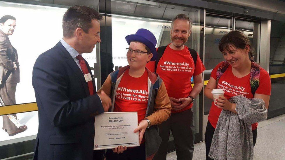 Alasdair Clift with mother Caroline and father Richard being presented a certificate at Southwark station