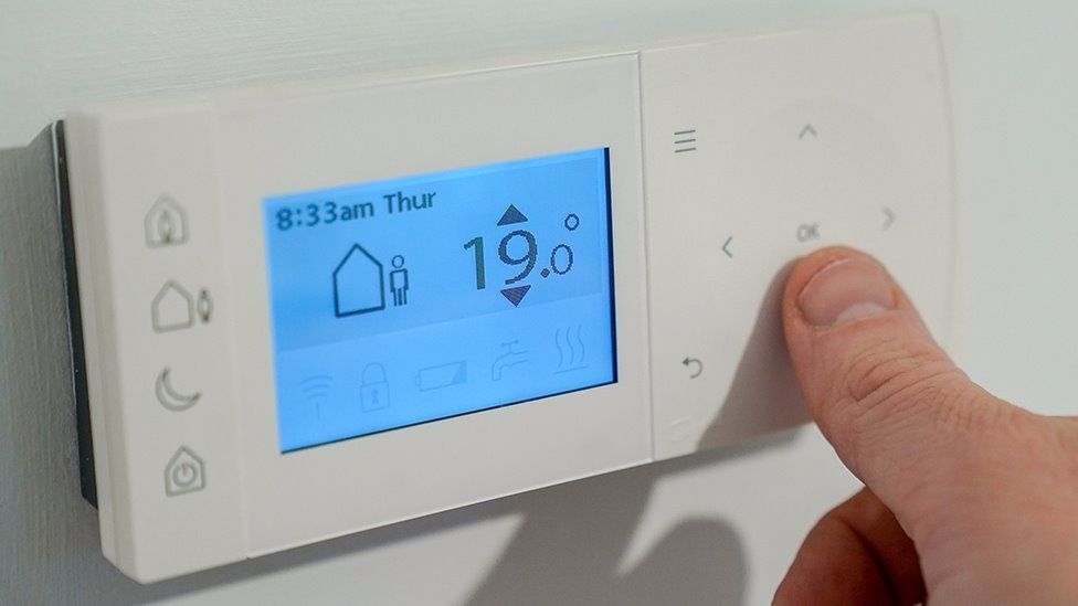 Person using a central heating thermostat