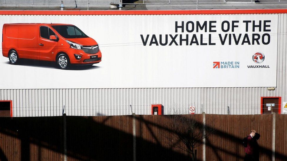 A person walks past a sign on Vauxhall's plant in Luton, Britain, March 6, 2017.