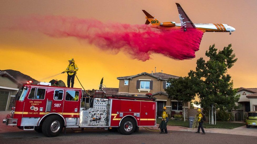 A plane drops fire retardant behind homes along McVicker Canyon Park Road in Lake Elsinore in the US