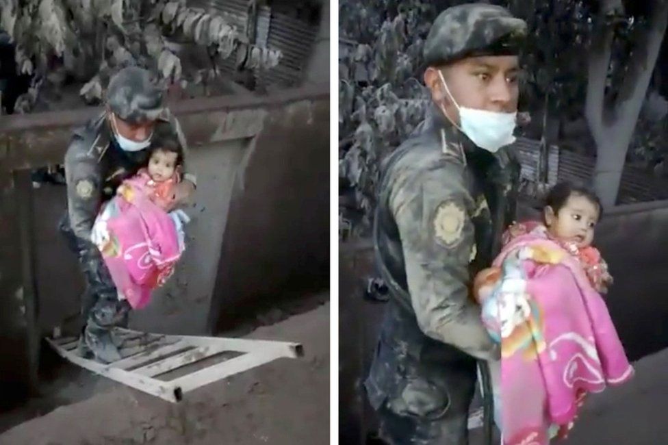 A soldier rescues a girl from a hole in an area affected by the eruption