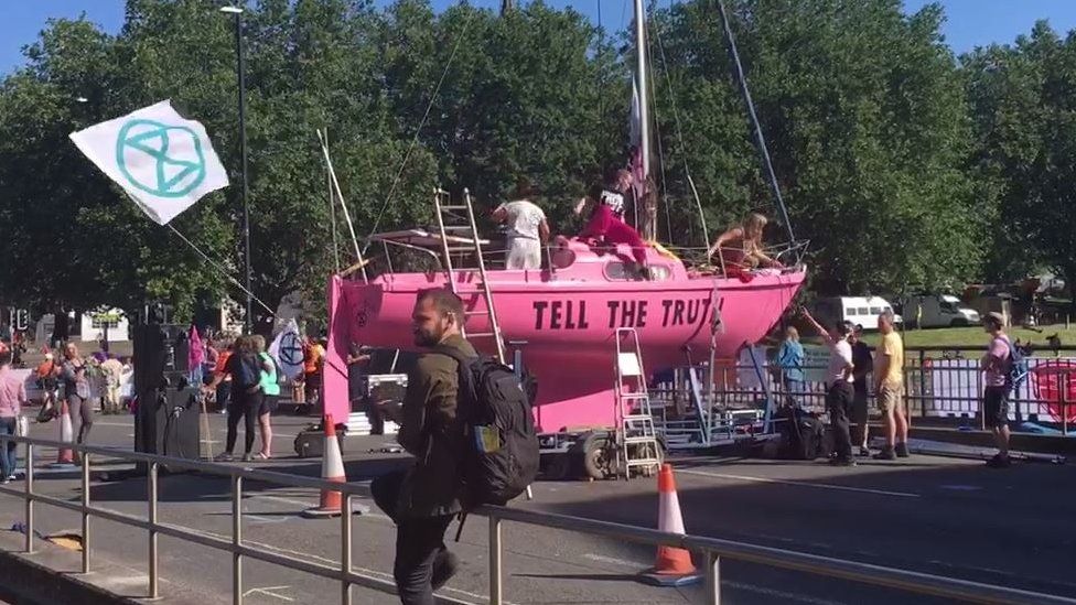 Extinction Rebellion protesters with a pink boat blocking Bristol Bridge