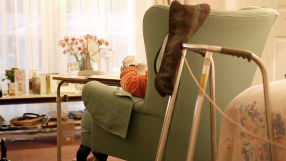 Generic picture of an elderly woman sitting in a chair at a care home