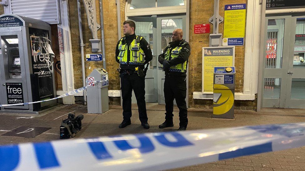 Police officers stood behind a cordon at Beckenham Junction station