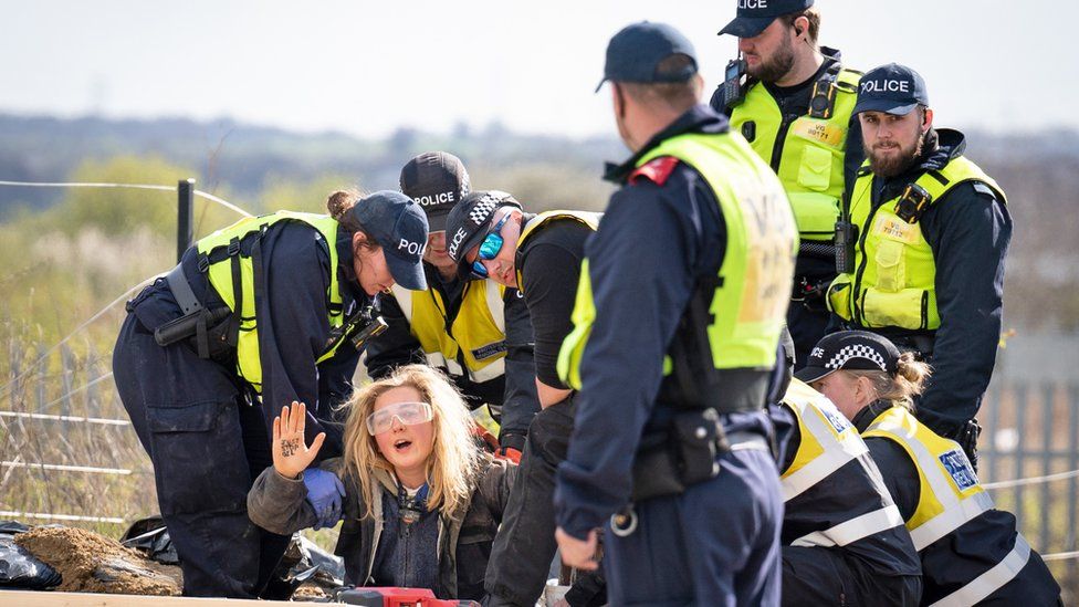 Police officers from the Protester Removal Team work to free a Just Stop Oil activist who is part of a blockade at the Titan Truck Park in Grays, Essex