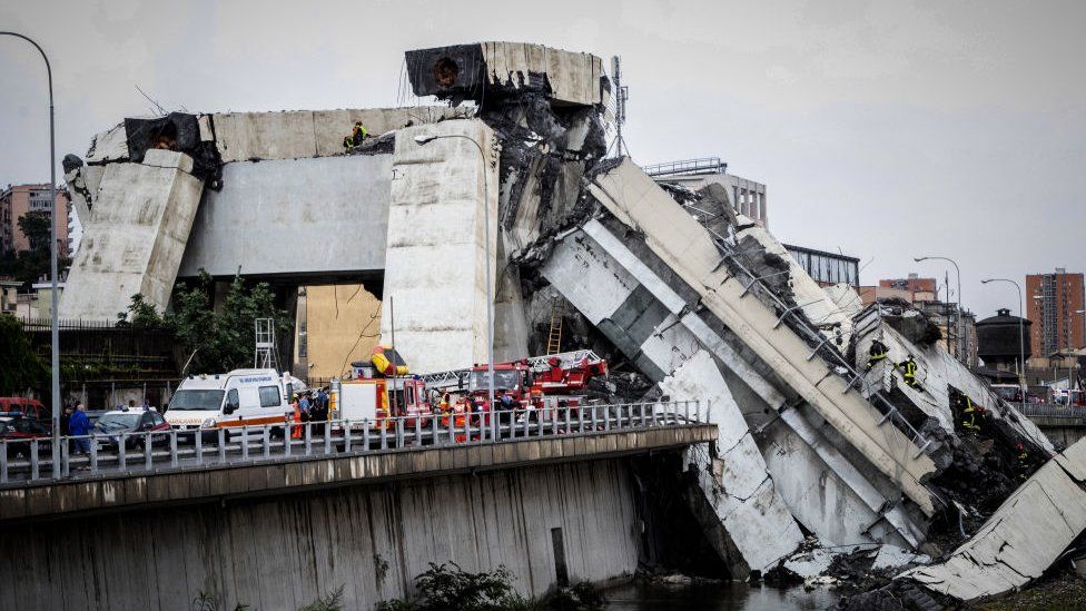 A picture taken on August 14, 2018 shows rescue workers on a part of a Morandi motorway bridge