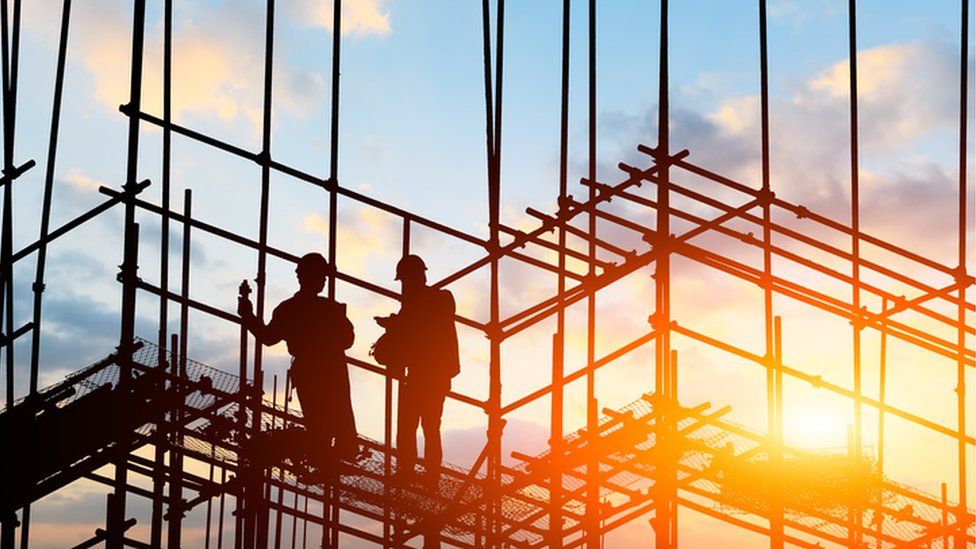 Builders standing on scaffolding on a construction site