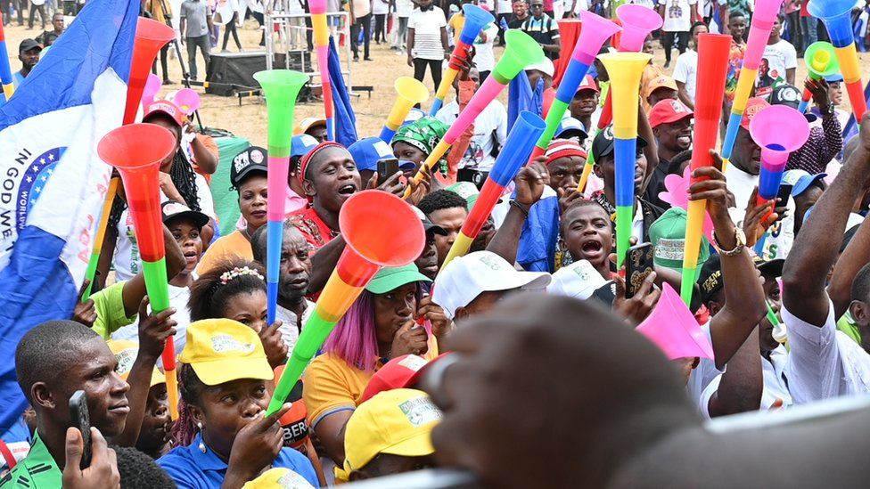A crowd holding vuvuzelas