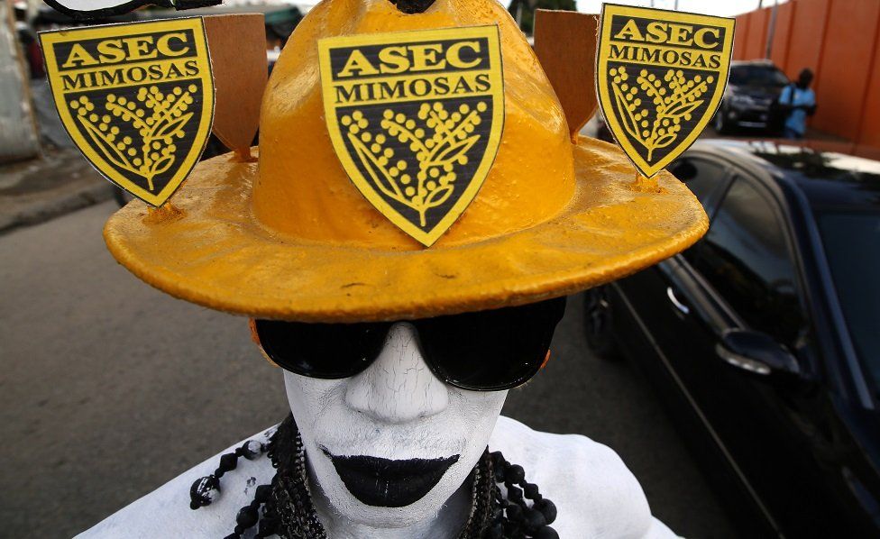 An Asec Mimosas supporter in yellow, black and white.