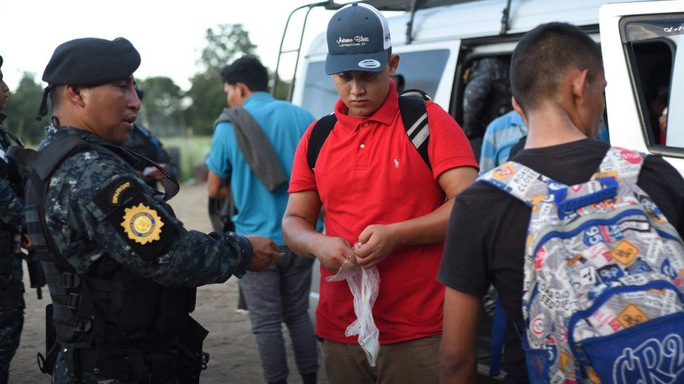 Guatemalan police agents check documents of Hondurans migrants at El Cinchado
