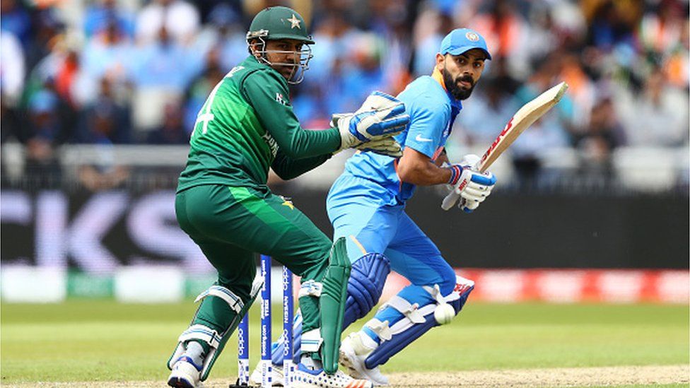 Рохит Шарма из Индии ныряет, чтобы закрепиться, а Сарфраз Ахмед наблюдает за матчем группового этапа чемпионата мира по крикету ICC 2019 между Индией и Пакистаном на «Олд Траффорд» 16 июня 2019 года в Манчестере, Англия. ||
