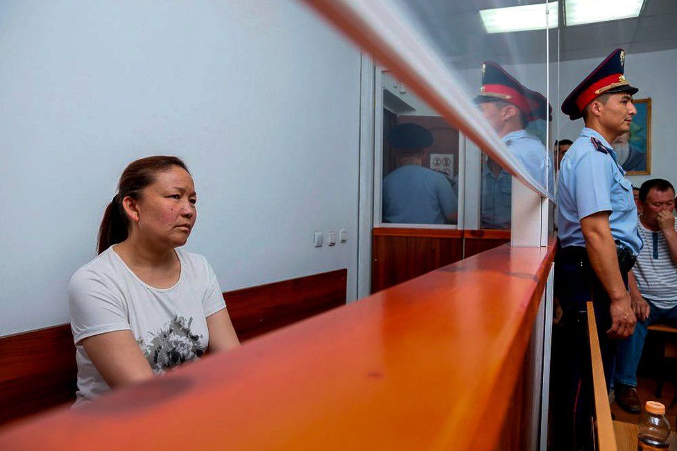A picture taken on July 13, 2018 shows Sayragul Sauytbay, 41, an ethnic Kazakh Chinese national and former employee of the Chinese state, who is accused of illegally crossing the border between the countries to join her family in Kazakhstan, sits inside a defendants' cage during a hearing at a court in the city of Zharkent.