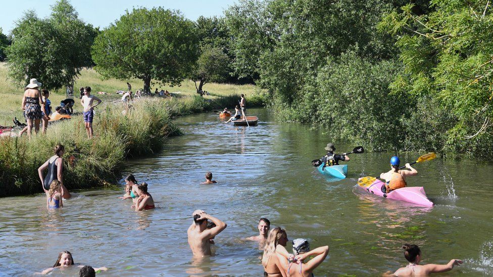 People play in the River Cam in Grantchester near Cambridge