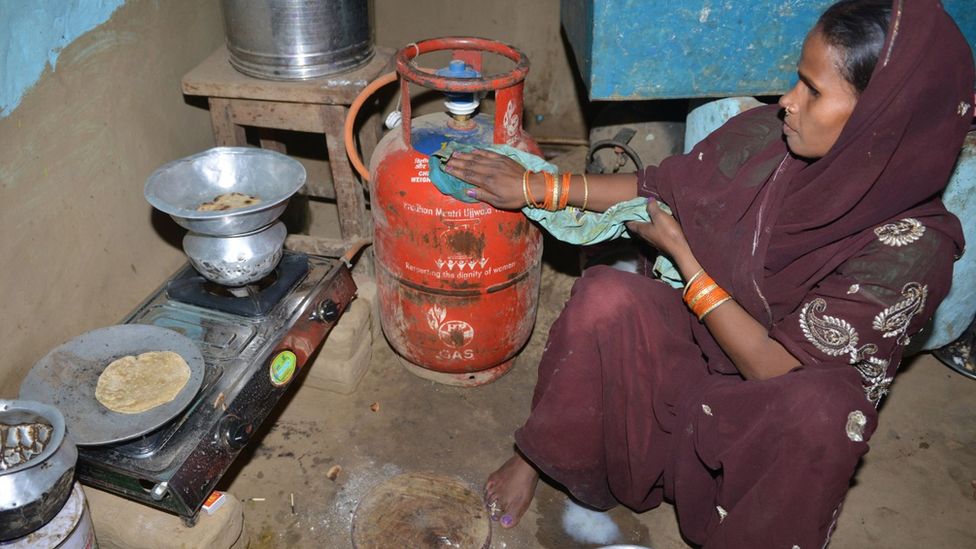 Woman in India prepares to cook with a cylinder of liquefied petroleum gas