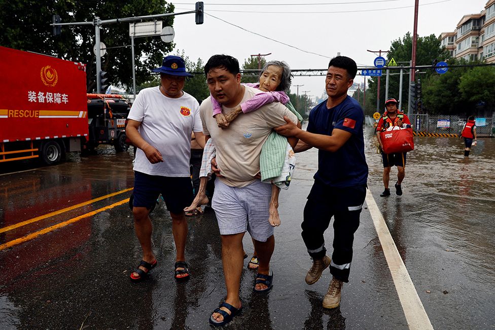 Rescue workers help evacuate an elderly woman after remnants of Typhoon Doksuri brought rains and floods in Beijing, China August 2, 2023. REUTERS/Tingshu Wang TPX IMAGES OF THE DAY