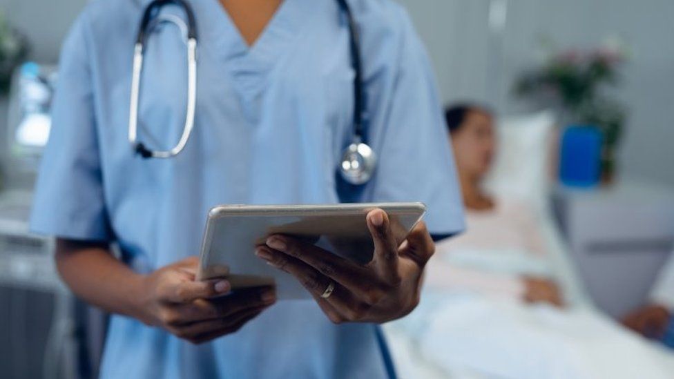 Медицинский работник в больнице держит планшет