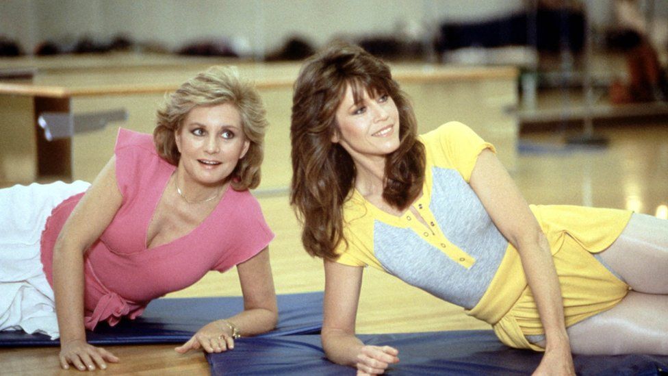 Jane Fonda and another woman exercising on the floor