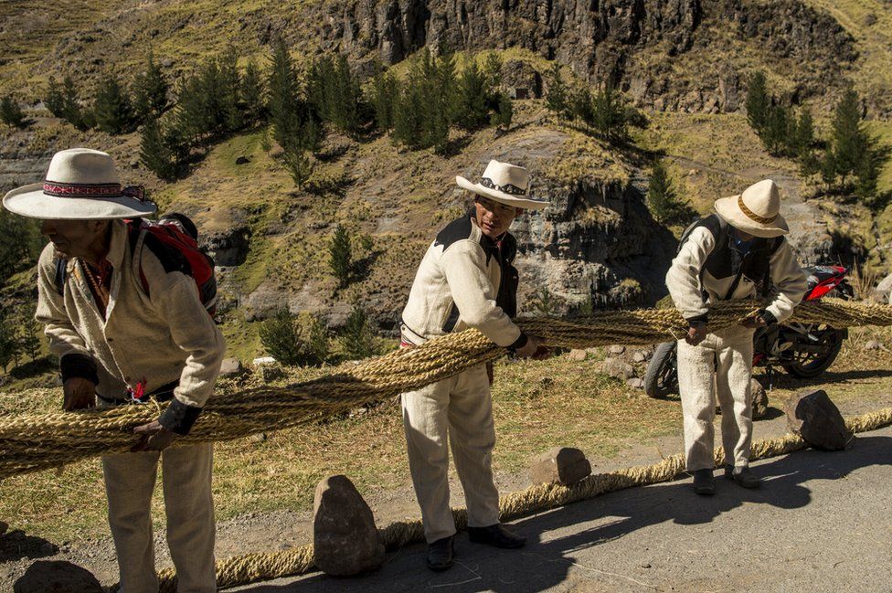 Men hold one of the thicker ropes