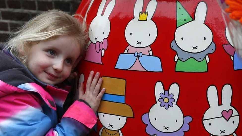 A girl hugs a Miffy statue outside the Nijntje Museum, or Miffy Museum in Utrecht (17 February 2017)