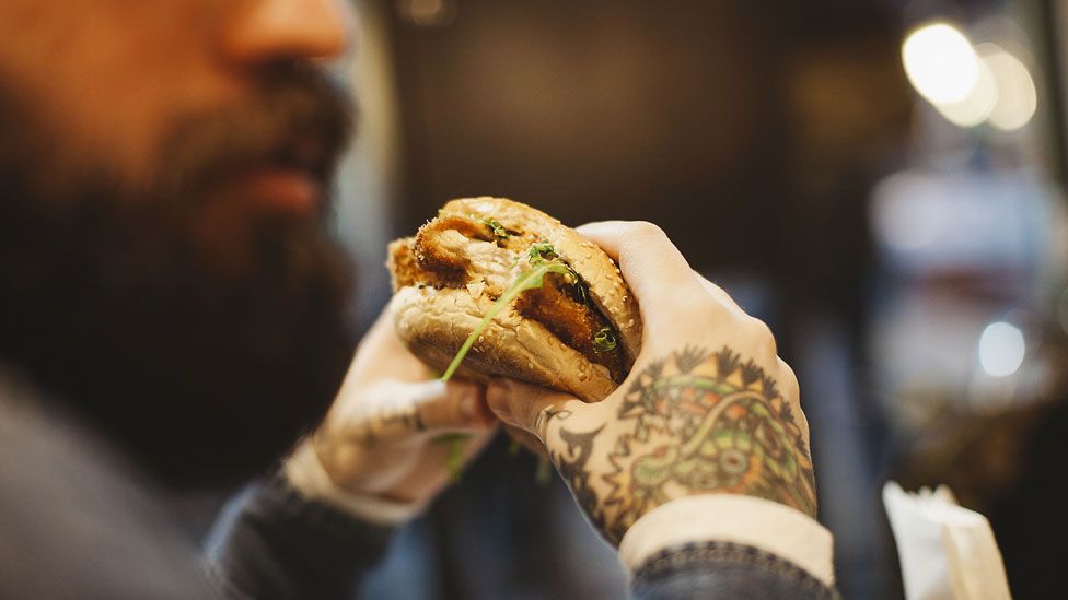 Stock image of a man eating a burger