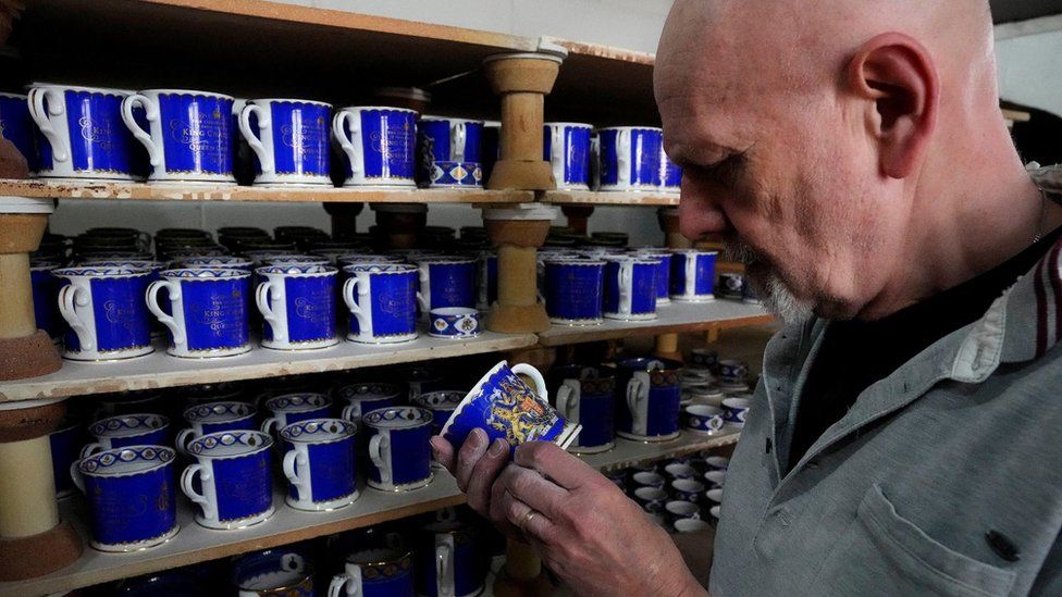 A worker checks the quality of official chinaware at a pottery factory in Stoke-on-Trent