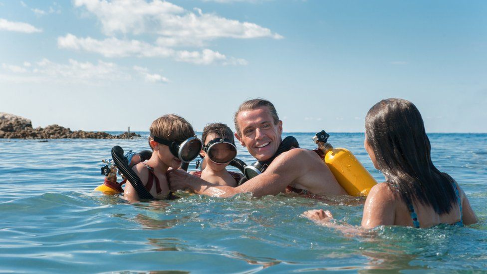 The Cousteau family in the sea in a scene from the film