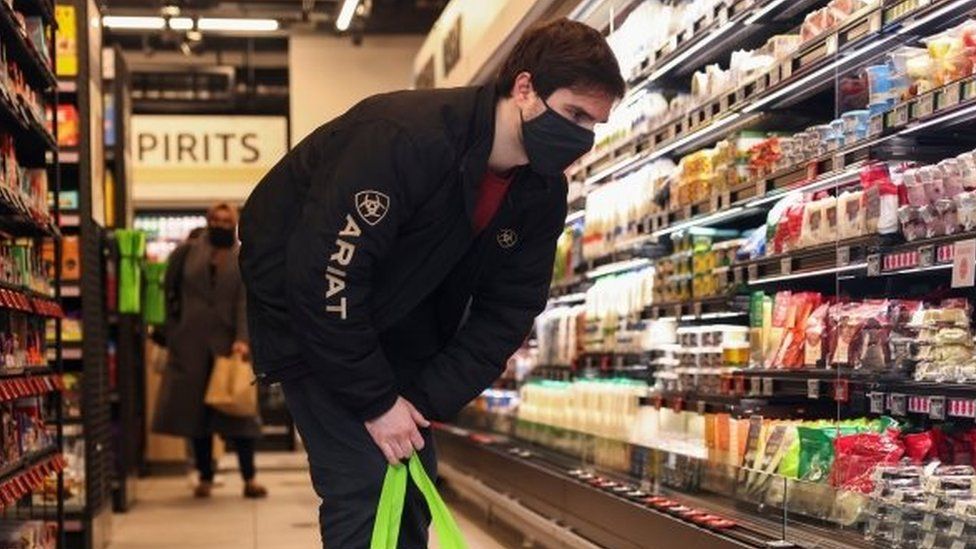 A person shops at an Amazon Fresh store in London