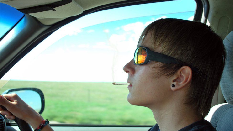 Young driver smoking at the wheel