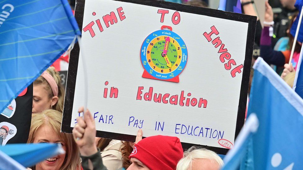 A sign that reads: Time to invest in education. Fair pay in education