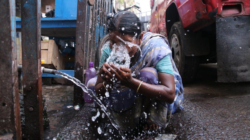 A woman splashes water on her face to get relief from extreme heat during hot weather, Kolkata