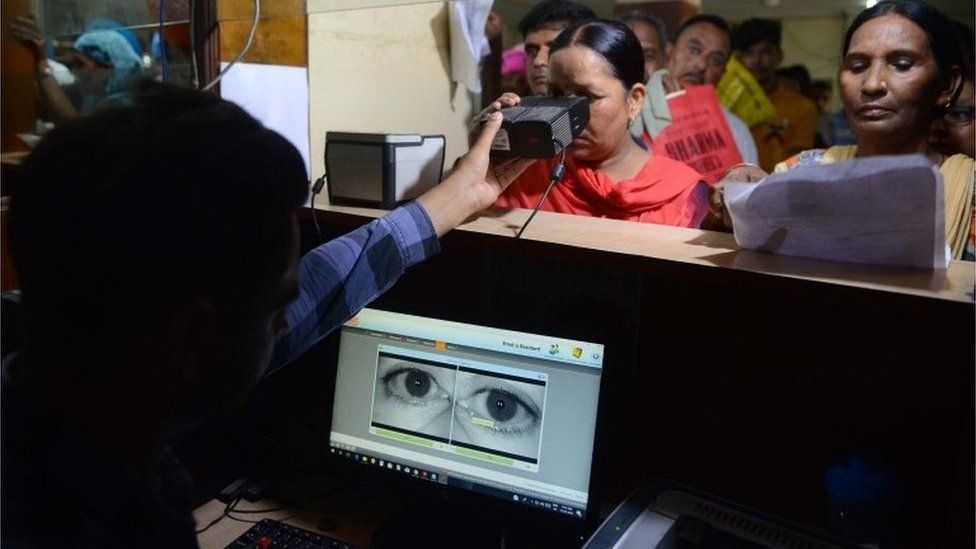 This photo taken on July 17, 2018 shows an Indian woman looking through an optical biometric reader that which scans an individual's iris patterns, during registration for Aadhaar cards (or unique identifier [UID] cards) in Amritsar