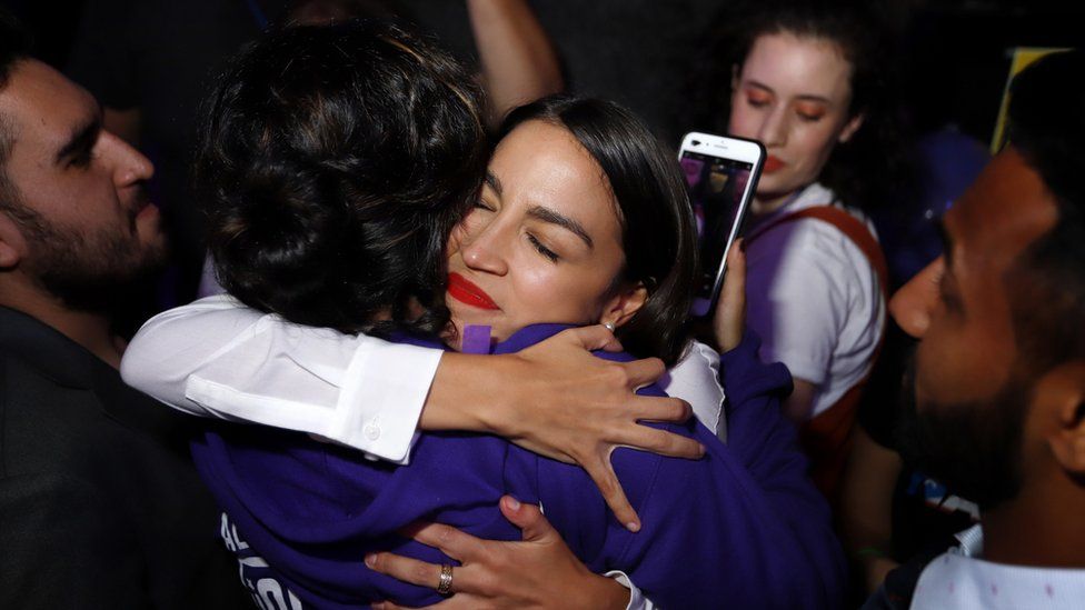 Alexandria Ocasio-Cortez hugs a supporter during her victory celebration