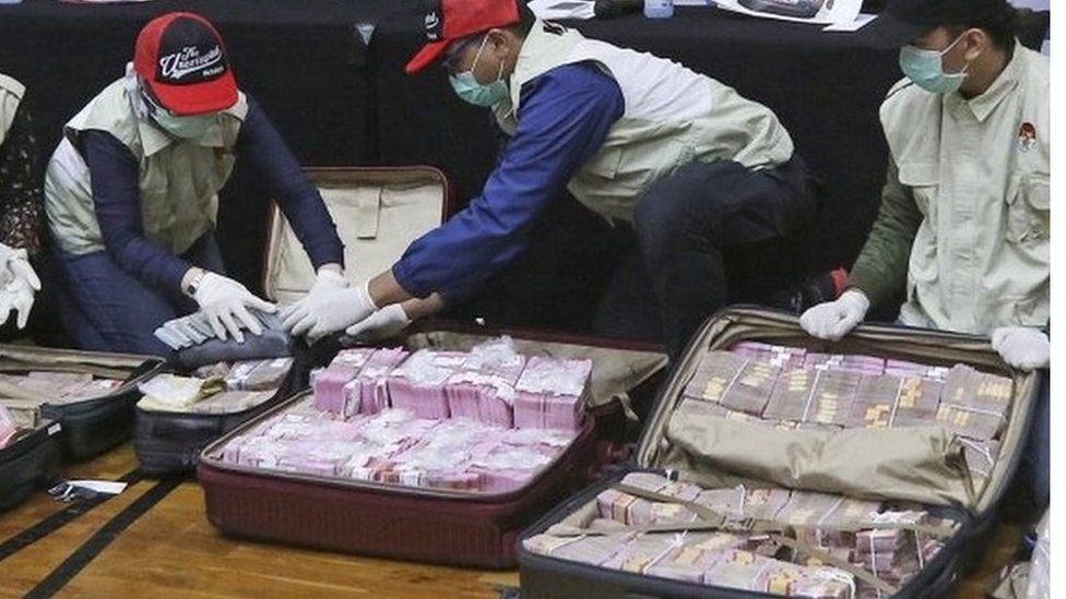 Officers show the suitcases filled with cash