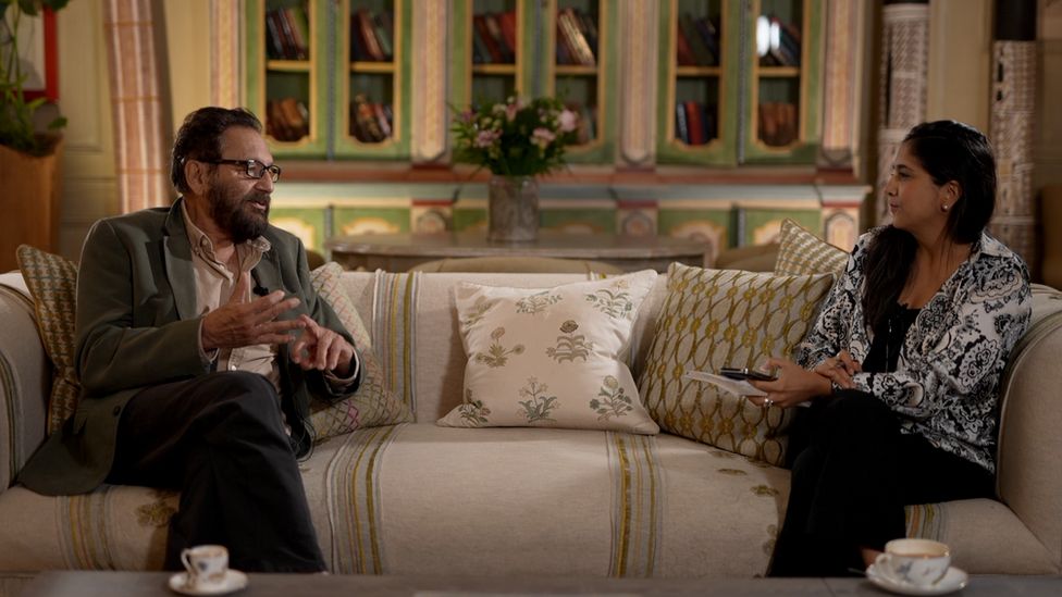 Shekhar Kapur sits on sofa with Sima Kotecha