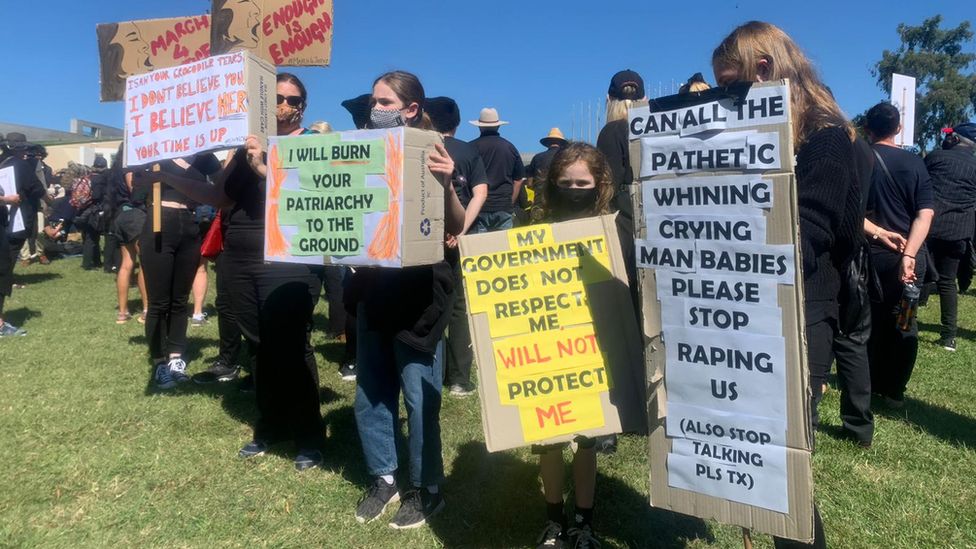 Protesters hold placards and signs during the March 4 Justice rally in Canberra