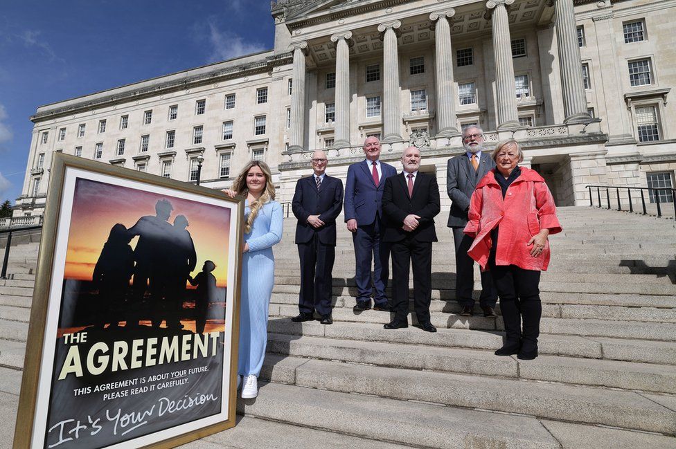 Fifteen-year-old Jessica-Elise McArdle holds a large, framed print of the Good Friday Agreement on the steps of Stormont's Parliament Buildings as Assembly Speaker Alex Maskey and former Stormont politicians Billy Hutchinson, Mark Durkin, Gerry Adams and Monica McWilliams stand by her side