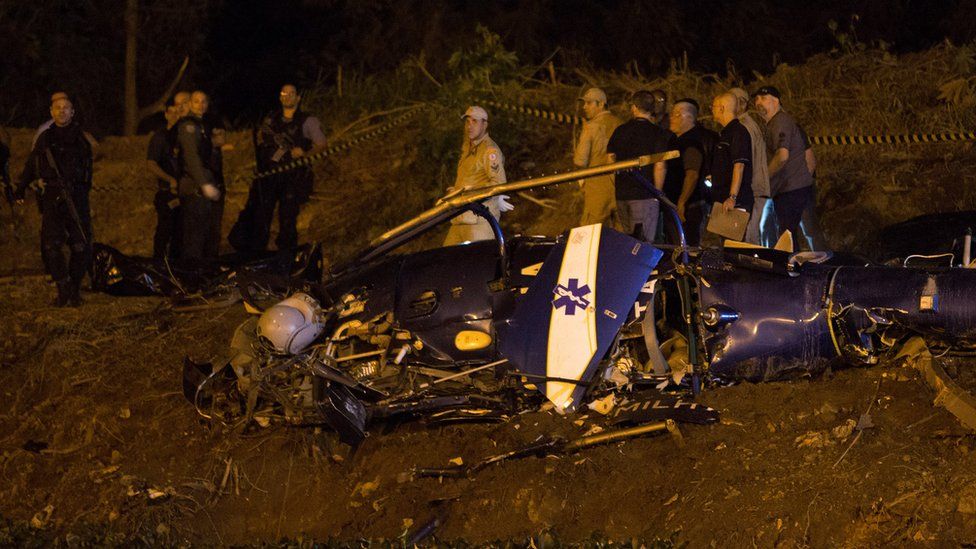 Police gather at a military helicopter which crashed in Rio de Janeiro, Brazil on Saturday, Nov. 19, 2016.