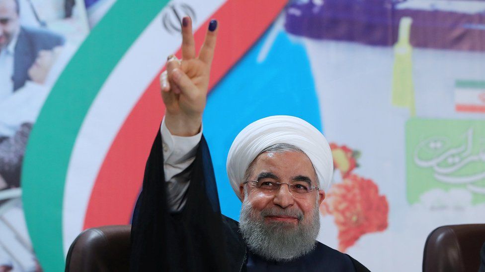 Hassan Rouhani holding up fingers covered in ink