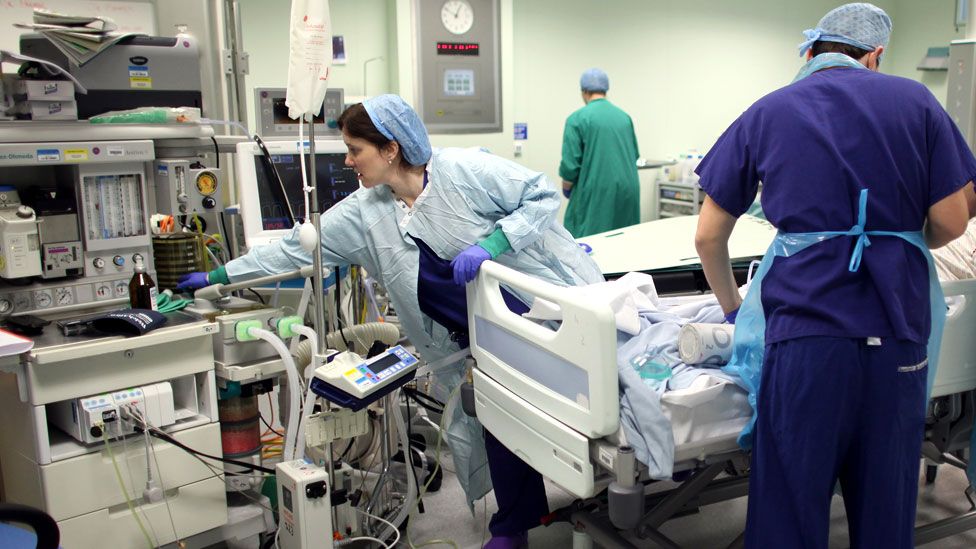 Operating theatre staff care for a patient in the Birmingham Queen Elizabeth Hospital on 2 February 2011 in England