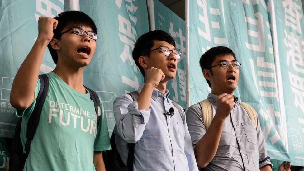 Leaders of Hong Kong"s "Umbrella Revolution" (L to R) Joshua Wong, 19, Nathan Law, 23, and Alex Chow, 25, shout slogans upon their arrival outside the Eastern Court in Hong Kong on August 15, 2016.
