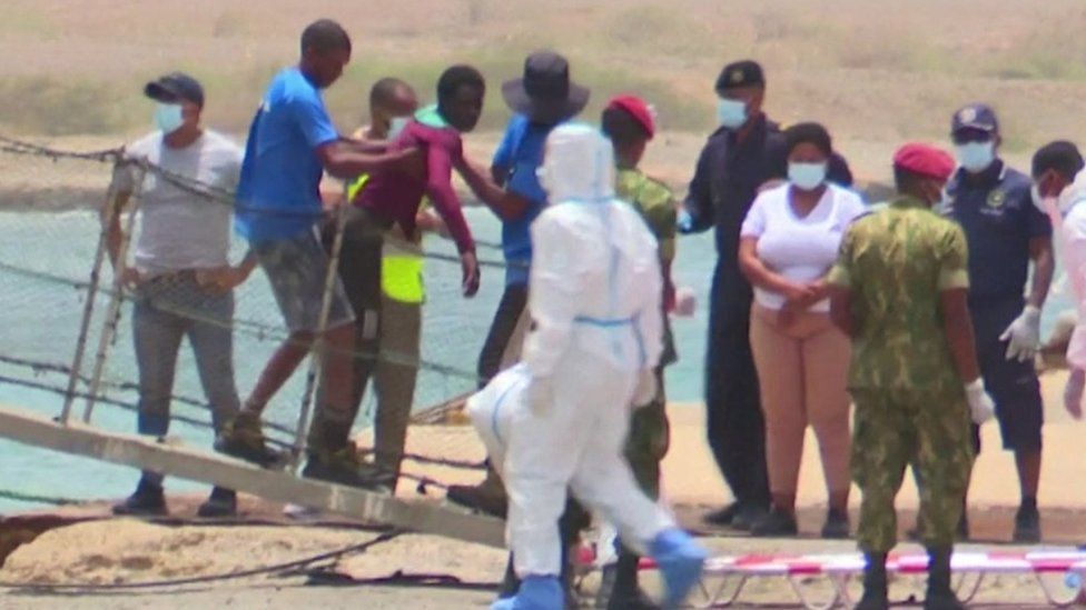 A survivor is helped ashore in Cape Verde