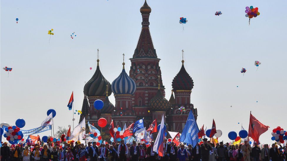 People celebrate May Day with flags, balloons, music and dancing on Red Square in Moscow