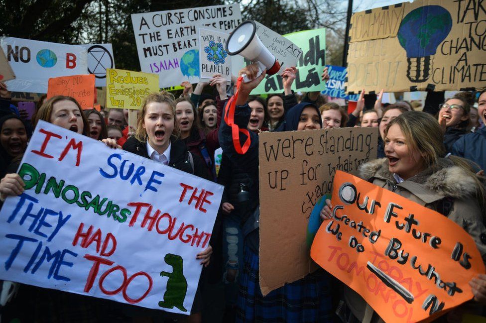 Young people carrying placards at a protest against climate change in Dublin