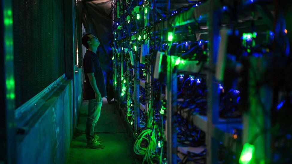 A Chinese bitcoin miner checks mining equipment inside their bitcoin mine in Sichuan province.