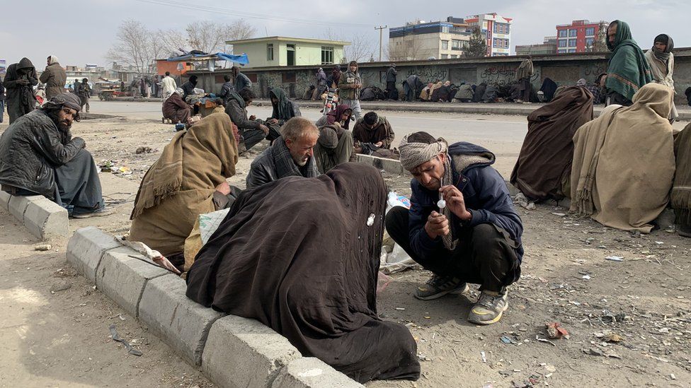 Men gathered on the side of the road in the capital, Kabul to use drugs