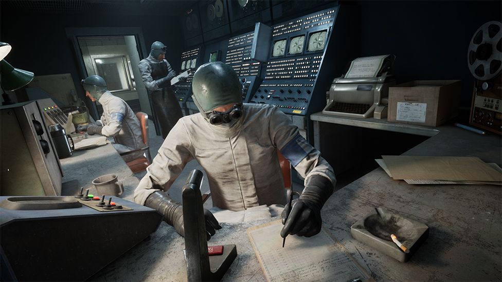 A man in white cover-alls sits at a desk furiously scribbling on a piece of paper. He's wearing safety goggles and a green head covering that sits tight on his head, like a swimming cap. In the background two colleagues, one sitting, one standing, wear the same uniform. The room looks like an old Soviet-era power station control room. There are various devices with rows of illuminated buttons, with a row of black and white screens on them. The room is mostly dark, with the desks illuminated by angle poise lamps. A heavy door with thick glass window appears to be the only exit. The mood is sinister, like the men are working on a nefarious experiment.