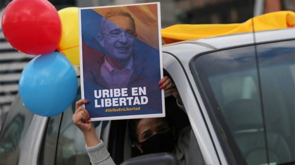 A supporter of Alvaro Uribe, former president and legislator of Colombia, wearing a face mask, holds a sign that reads "Uribe in freedom" during a protest against the house arrest measure ordered by the Supreme Court of Justice, against the former president in Bogota, Colombia August 7, 2020