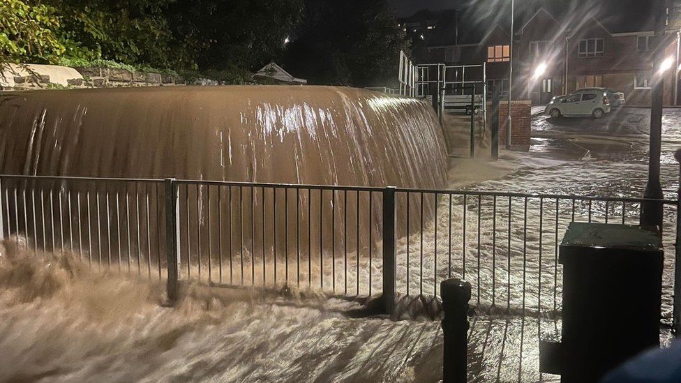Water was seen pouring over a wall in St Catherine's Close, in Melyn, Neath