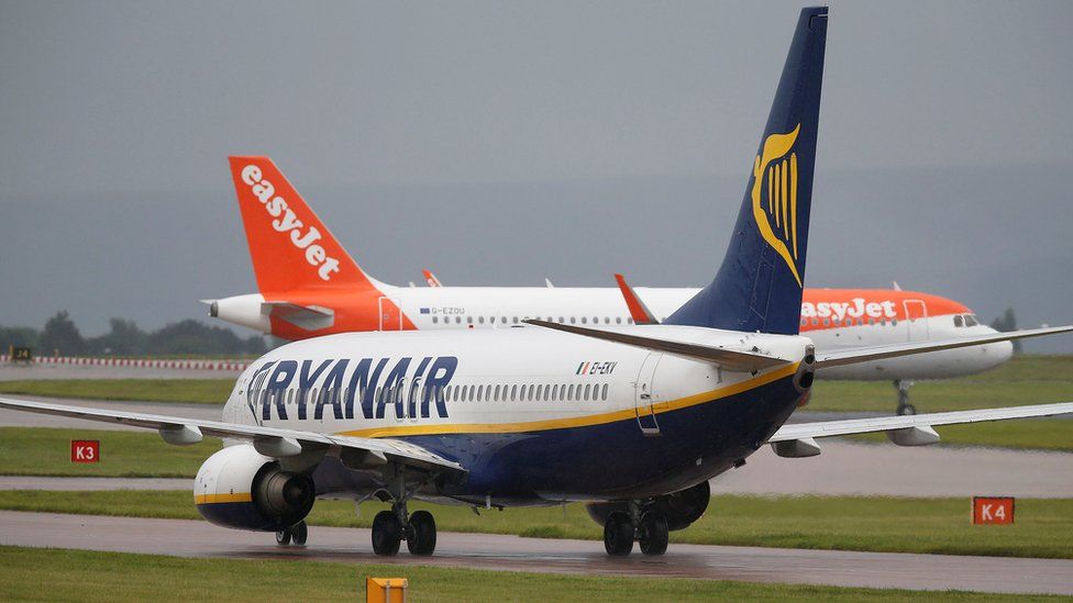 A Ryanair aircraft taxis behind an easyJet aircraft at Manchester Airport